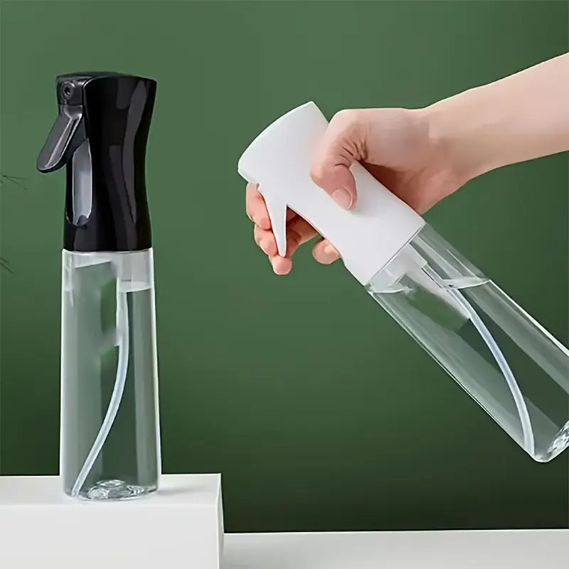Hand holding a white spray bottle with a clear body against a green background