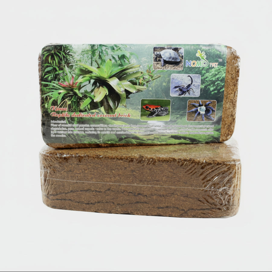 Two rectangular NOOMOY PET reptile wood-based substrate blocks stacked, with the top block showing printed packaging graphics of tropical plants and small animal photos on a white background.