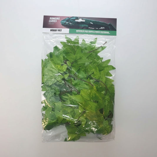 Packaged artificial green leaves in a clear plastic bag on a white background