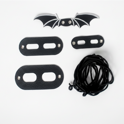 Set of black leather straps with a bat design on a white background