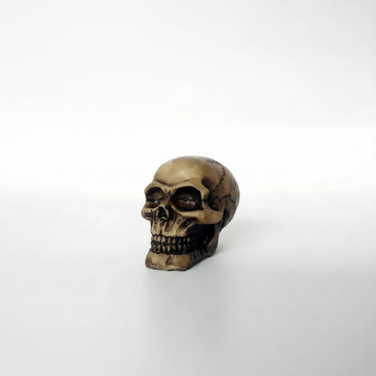 Bronze skull figurine on a white background 