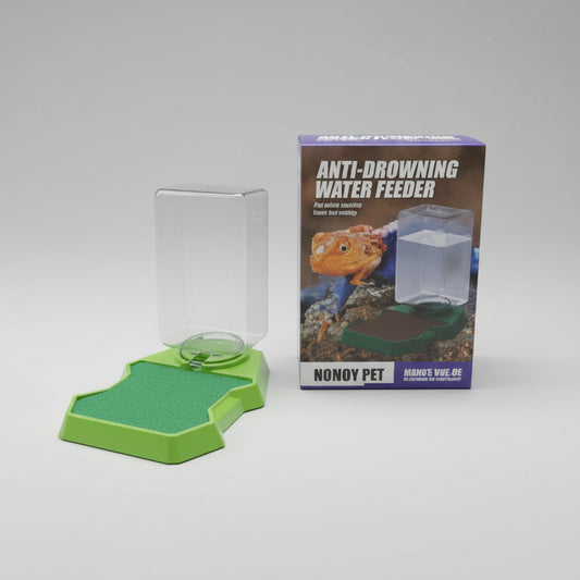 A small green plastic anti-browning water feeder and its retail box, shown on a tabletop with a wood-paneled background.