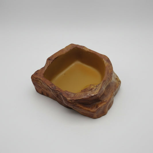 A reptile water dish with a naturalistic rocky brown